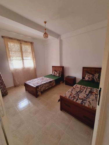 a bedroom with two beds and a window at Taida in Tizouiar