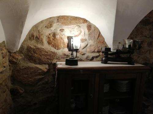 a table with a lamp on top of a stone wall at Casa Rural Canchalejo in Montánchez