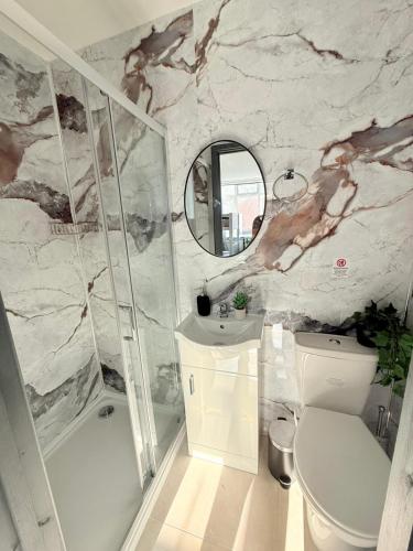 a bathroom with a toilet and a sink and a mirror at Little Venice Guest Rooms in London
