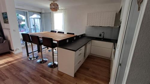 a kitchen with a table and chairs in a room at Chez Sofia T3 view port private parking and pool in Cap d'Agde