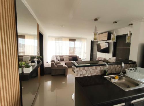 a kitchen and a living room with a couch at Hermoso Apartamento a 5 minutos del centro in Pasto