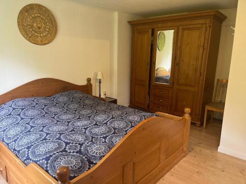 a bedroom with a wooden bed with a blue comforter at Stuga Gruvriset in Fredriksberg