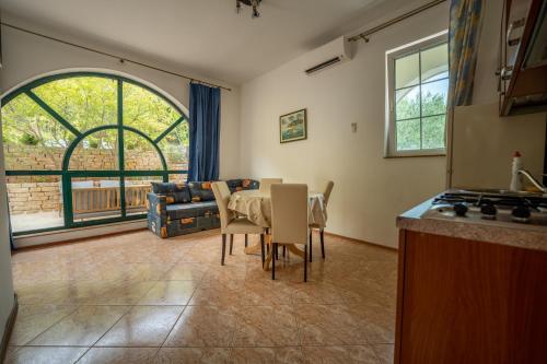 een keuken en eetkamer met een tafel en stoelen bij Beach Apartments Villa Holiday in Živogošće