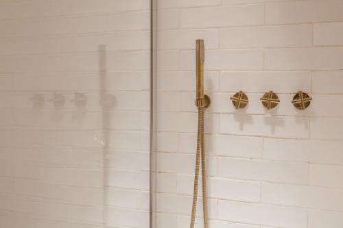 a shower in a bathroom with white tiled walls at Beige Tranquil Escape by the Sea in Matosinhos