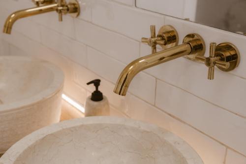 a bathroom with gold faucets and a sink at Beige Tranquil Escape by the Sea in Matosinhos