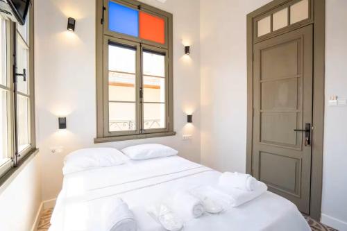 a white bed in a room with a window at Özel Otel in Ayvalık