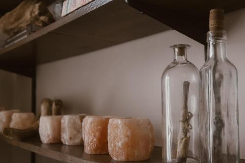 a shelf with glass bottles and donuts on it at Beige Tranquil Escape by the Sea in Matosinhos
