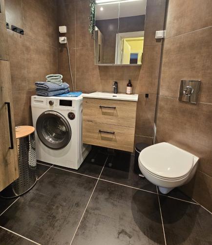 a bathroom with a washing machine and a toilet at Koselig hjem nær Carl Berner in Oslo