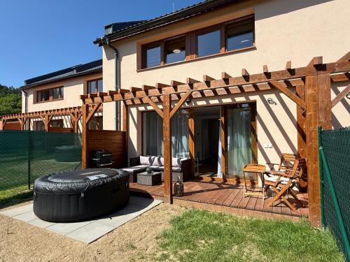 a patio with a large tire in front of a house at Objev Jeseníky Velké Losiny in Velké Losiny