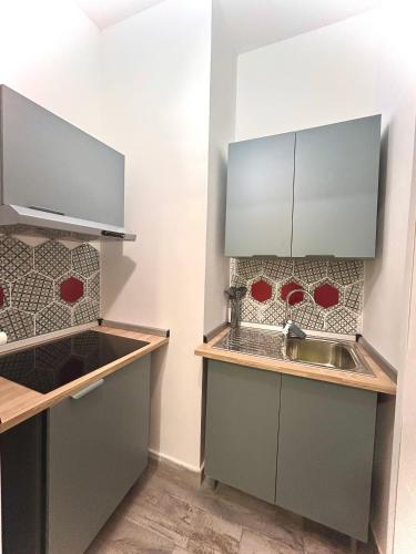 a kitchen with gray cabinets and a sink at Cabot Cove in Gaeta