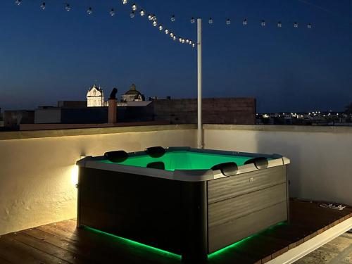 a hot tub on top of a rooftop at night at GIOSAHOUSE in Uggiano la Chiesa