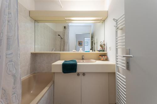 une salle de bain avec un lavabo et une baignoire dans l'établissement Poseïdon by Pom, au Cap d'Agde