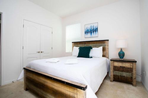 a bedroom with a large bed with a wooden headboard at Exclusive 8BR Family Villa - Pool, BBQ, Game Room & Themed Bedrooms! in Kissimmee