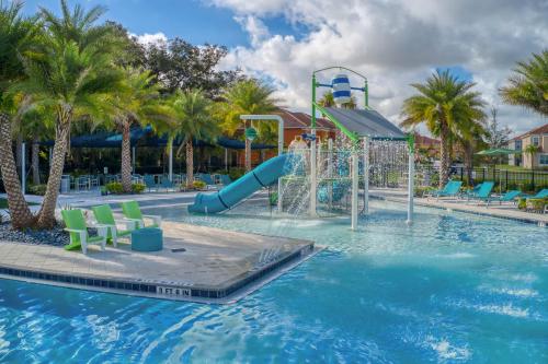 a pool at a resort with a water slide at Exclusive 8BR Family Villa - Pool, BBQ, Game Room & Themed Bedrooms! in Kissimmee