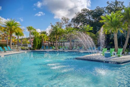 a swimming pool with a fountain in a resort at Exclusive 8BR Family Villa - Pool, BBQ, Game Room & Themed Bedrooms! in Kissimmee