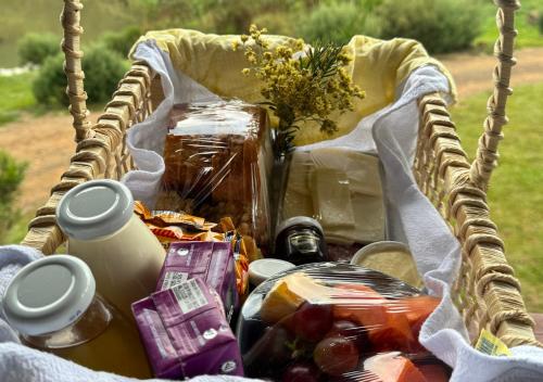un cestino da picnic con cibo e fiori dentro di Taipas de Urupema - Vinícola e Pousada Boutique a Urupema