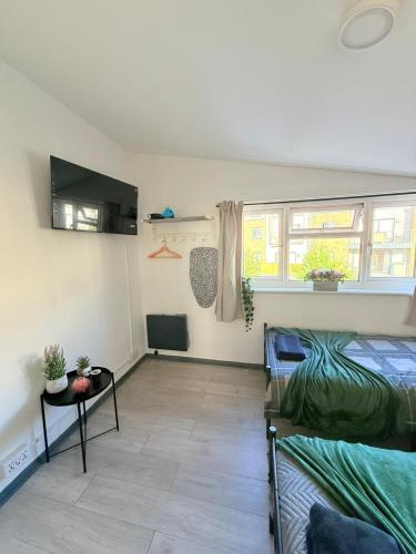 a room with two beds and a couch and a window at Little Venice Guest Rooms in London