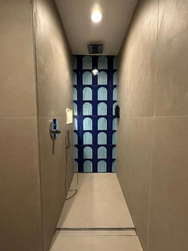 a bathroom with a hallway with a blue wall at Punta Campanella Resort & Spa in Massa Lubrense