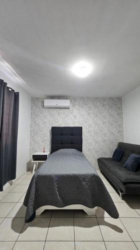 a bedroom with a large bed and a couch at casa Apodaca cerca del aeropuerto in Monterrey