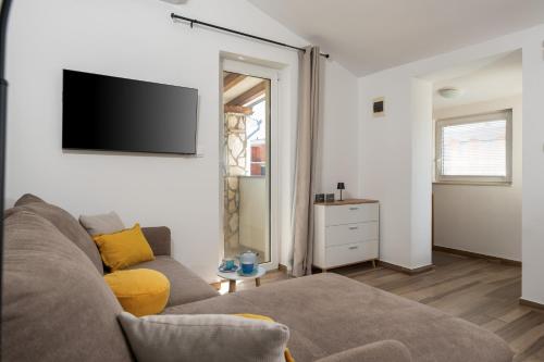 a living room with a couch and a flat screen tv at Luce Apartments in Ližnjan