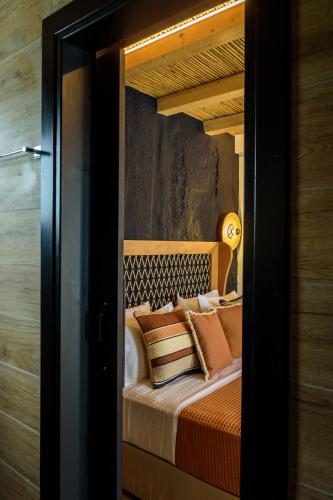 a bedroom with a bed with pillows on it at Olive Mykonos Villas in Ano Mera
