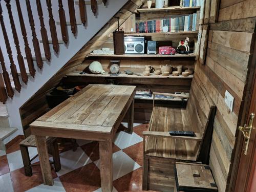 a wooden table and bench in a room with stairs at Molino Romano in Alcalá del Valle