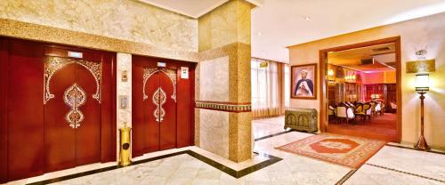 a lobby with wooden doors and a dining room at Zalagh Parc Palace in Fès