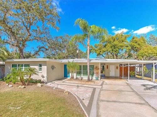 a house with a palm tree in front of it at The Modern Palms few mins from Downtown Tampa Ybor city in Tampa