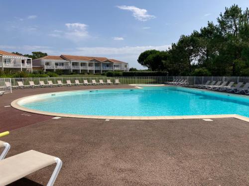 - une grande piscine avec des chaises longues dans la cour dans l'établissement Les Sables-d'Olonne - Terrasse, Wifi Fibre & Piscine, à 200 m de la Mer - D012, à Les Sables-dʼOlonne