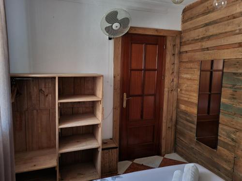 a bathroom with a wooden door and a fan at Molino Romano in Alcalá del Valle
