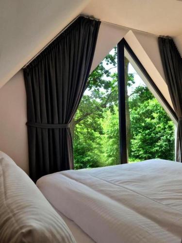 a bedroom with a bed and a window with trees at Treehouses in Skorochów