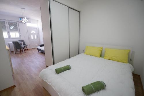 a bedroom with a large white bed with yellow pillows at Le Nina Apartments - Deluxe and Studio in Strumica