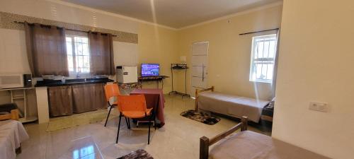 a room with a kitchen and a living room with a bed at Pousada Itatiba Holliday in Itatiba