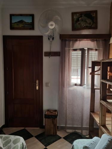 a room with a door and a window with a fan at Molino Romano in Alcalá del Valle