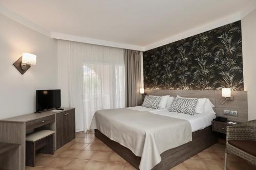 a hotel room with a bed and a television at Hotel Puerto Palace in Puerto de la Cruz