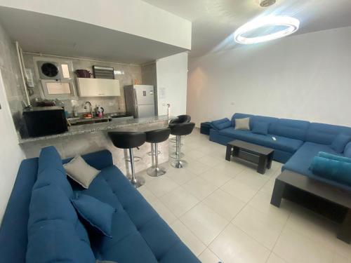 a living room with a blue couch and a kitchen at Palmera El Sokhna Chalets Families Only in Ain Sokhna