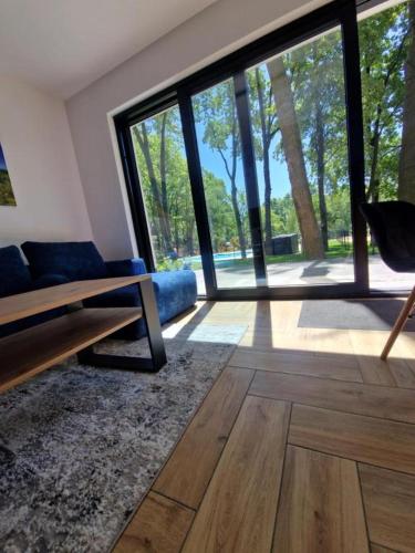 a living room with a couch and a large window at Treehouses in Skorochów