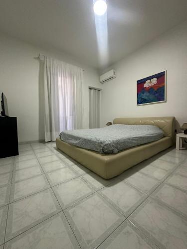 a bedroom with a bed and a tiled floor at Gioia Guest House in Torre del Greco
