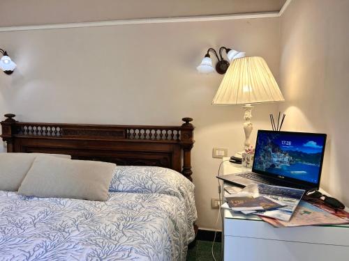 a bedroom with a bed and a laptop on a desk at bed and breakfast mery sorrento in Piano di Sorrento