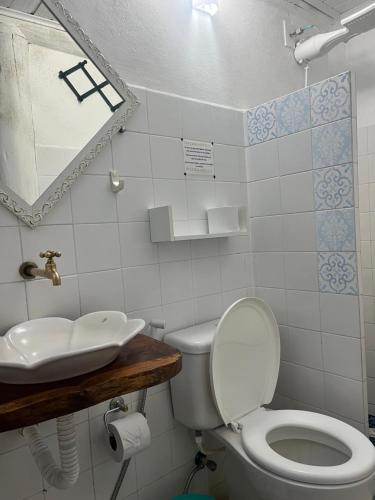a bathroom with a toilet and a sink at Pousada Casa da Praia Itaúnas in Itaúnas