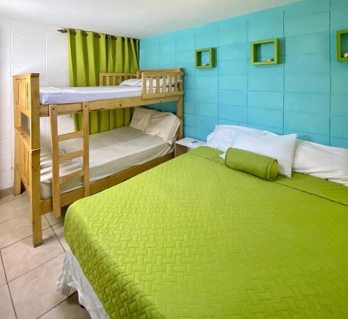 una camera con 2 letti a castello e un letto verde di Mangomar Beach House a Teotepeque