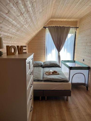 a bedroom with a bed and a desk and a window at Aster domki Sarbinowo in Sarbinowo