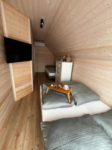a room with a bed and a tv in a cabin at Aster domki Sarbinowo in Sarbinowo