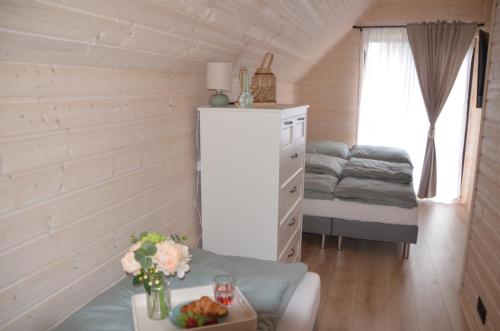 a small room with a table and a dresser at Aster domki Sarbinowo in Sarbinowo