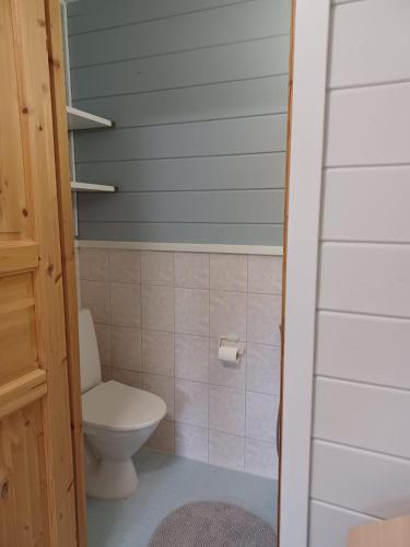 a bathroom with a toilet and a blue wall at Huipunpuisto B, sähköauton lataaminen sisältyy vuokraan in Syöte
