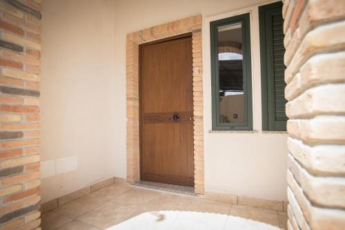 a wooden door in a room with a brick wall at Grappolo B&B affittacamere in Ascea
