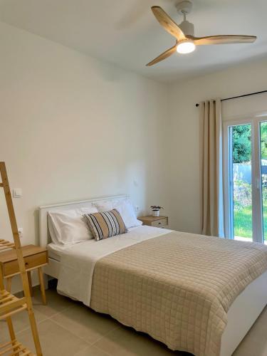 a bedroom with a bed with a ceiling fan at Tati apartment 2 in Kassiopi