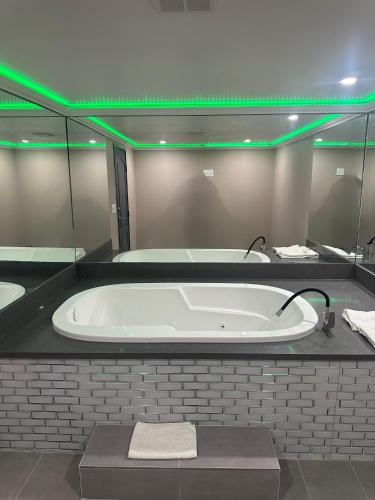 a large bath tub with green lights in a bathroom at Stardust inn in Azusa
