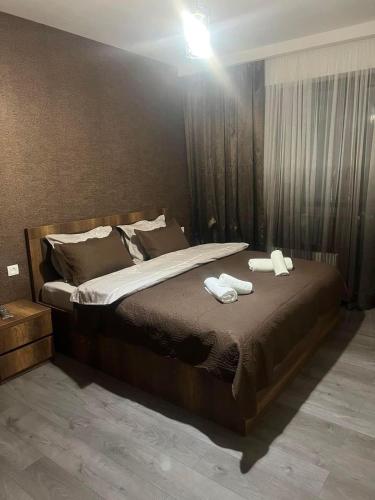 a bedroom with a large bed with two towels on it at Elit Chalet with 2 bedrooms in Bakuriani