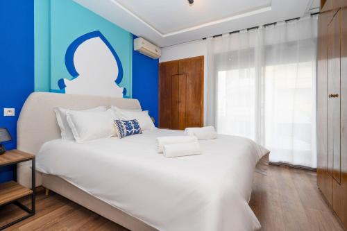 a bedroom with a large white bed with blue walls at CASA B l'hôtel in Casablanca
